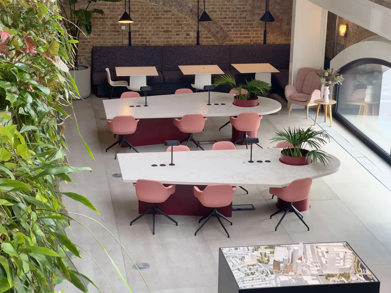 Two bespoke meeting tables with terrazzo-style tops made from reworked flooring, on monoblock bases with integrated planters - a REFRAME custom project