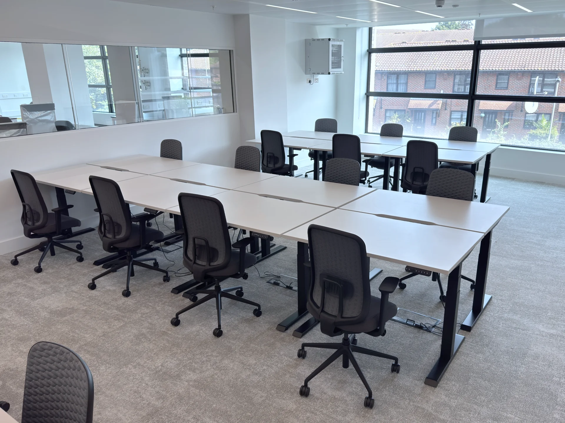 R!se sit-stand desks configured as linked bench desks in modern co-working office